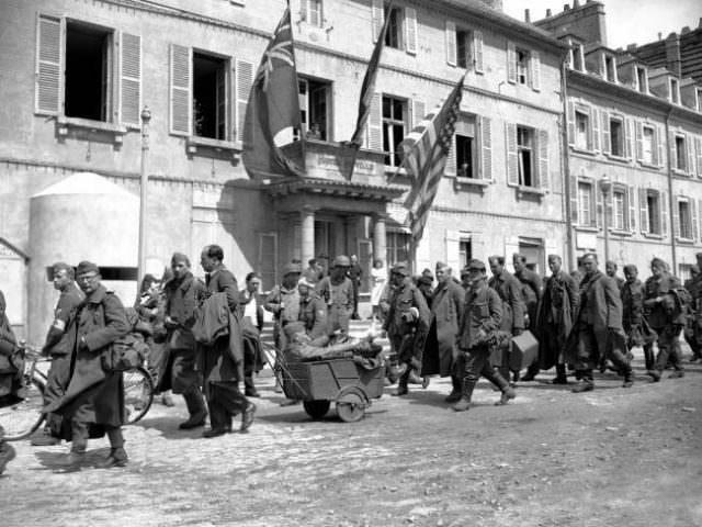 German prisoners file past the Town Hall at Cherbourg on their way to a stockade on June 28, 1944.
