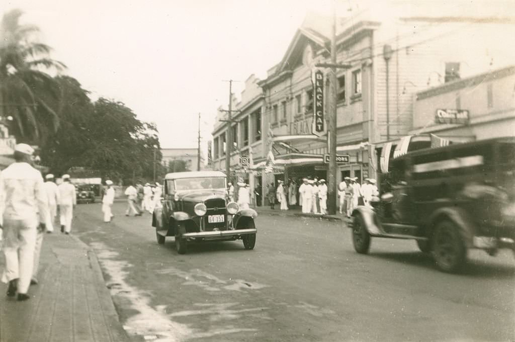 Numerous sailors on both sides and crossing city street, 1940s