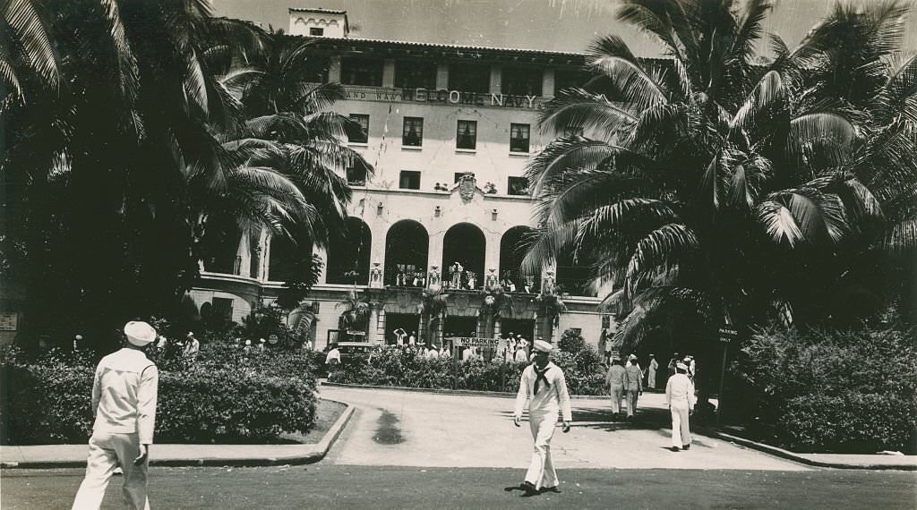 Sailors walking in front of six story building, 1940s