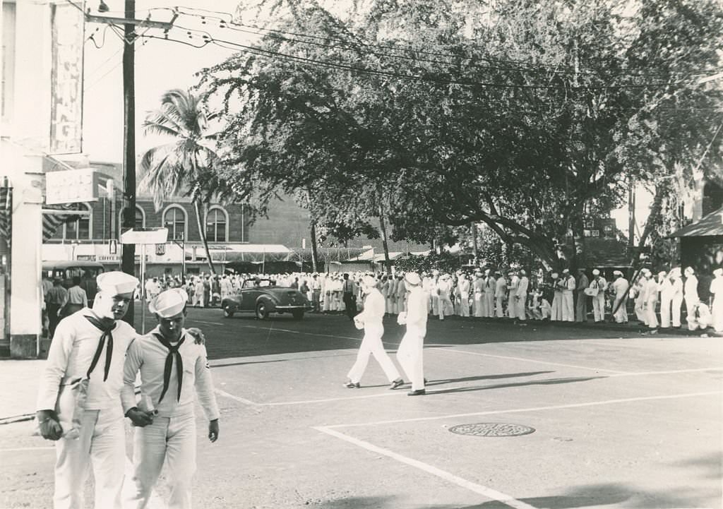 Long line of sailors. A few other sailors crossing street, 1940s