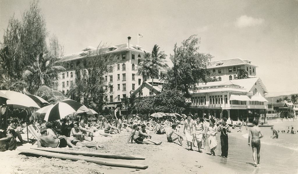 Crowded beach scene with sun umbrellas, 1940s