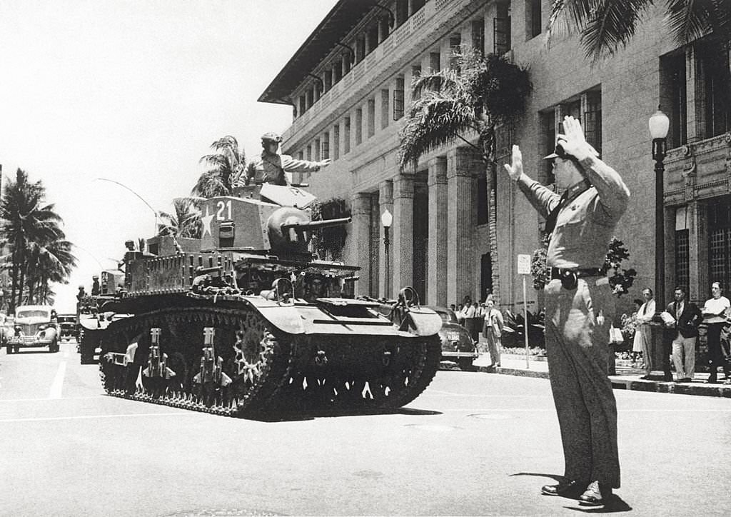 In Honolulu a policeman runs traffic to allow the passage of a line of tanks. Honolulu, March 1942