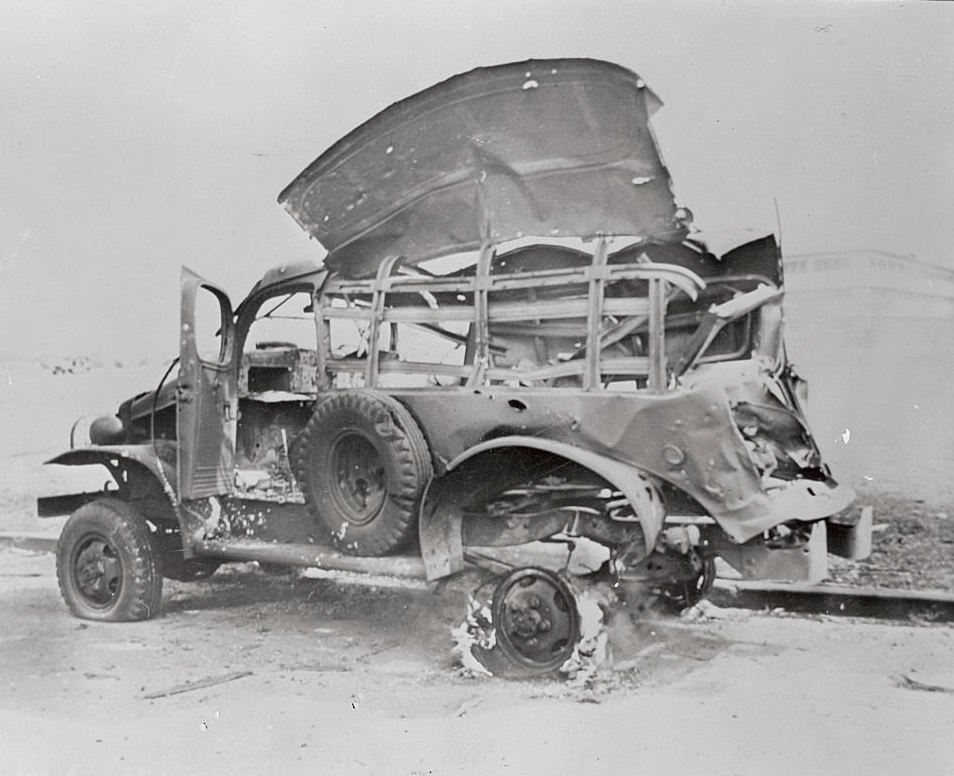 A bombed truck still burns off the Hickam Field Parade Ground at "F" Street, three hours after the first Japanese planes appeared over the Hawaiian Island of Oahu, on December 7, 1941.