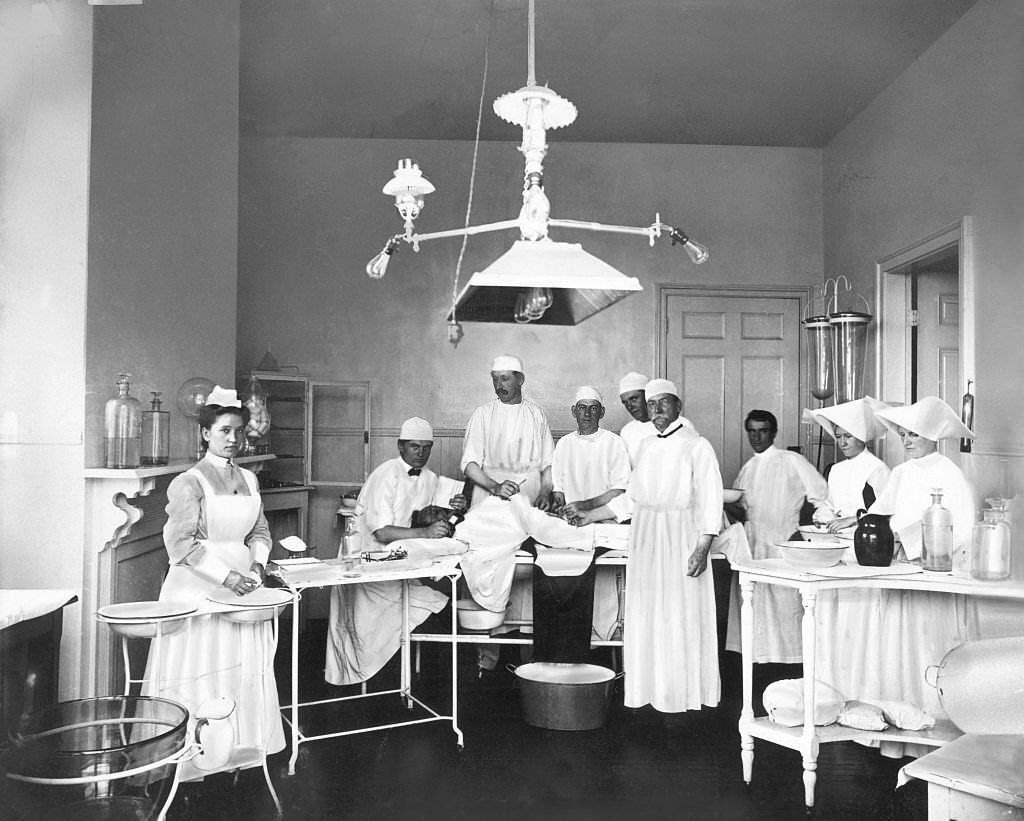 Operating room in a Mobile, Alabama, 1900s. The doctors and nurses pose before operating on a patient.