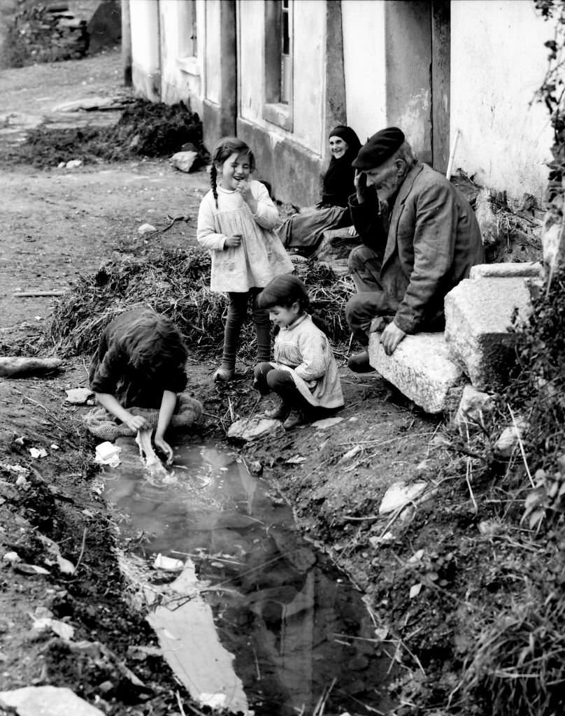 Woman washing clothes in a puddle, Barella, Galicia, Spain, 1963.