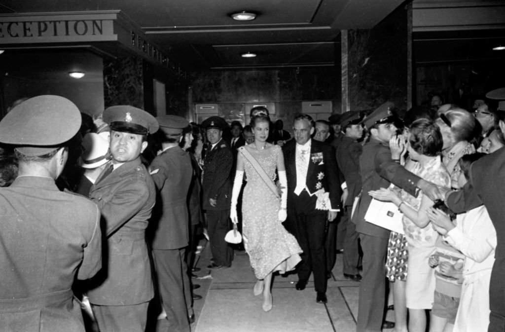 Prince Rainier III of Monaco and Grace of Monaco, in the hotel lobby waiting to be transferred to the celebration party of the wedding between Don Juan Carlos of Bourbon and Dona Sofia of Greece, 1962.