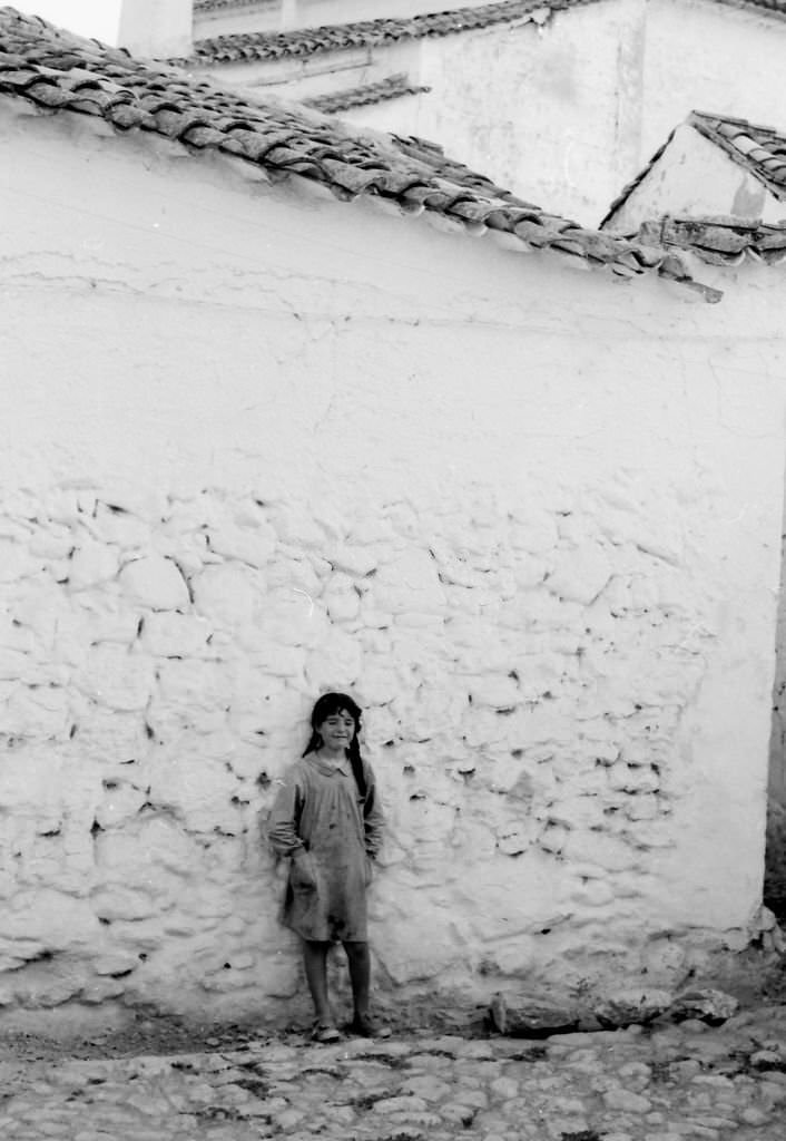 Lonely girl leaning against a wall in El Toboso, Castilla La Mancha, Spain, 1962.