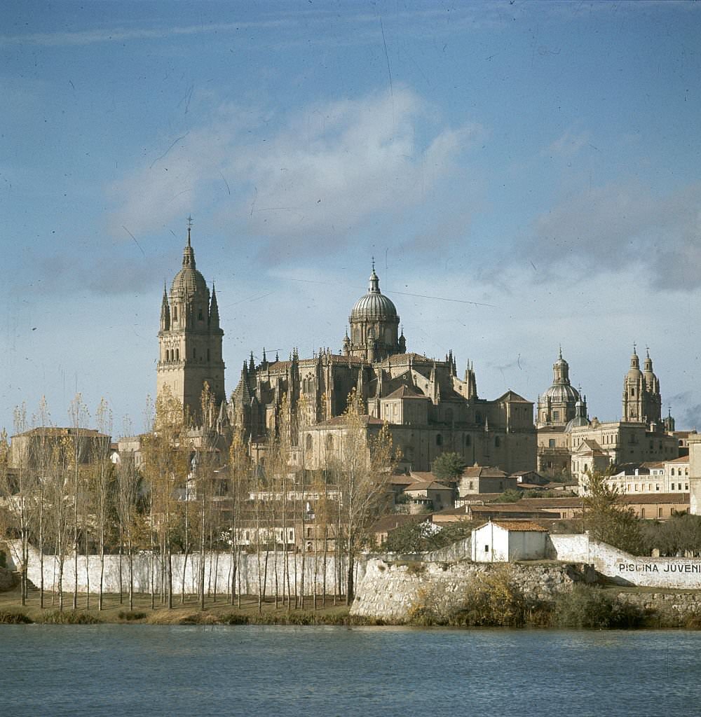 A view across the Tormes River of Old Salamanca, with the tower of the university at left, the cathedral, and the Church of Clerecia. The university is the oldest in Spain.