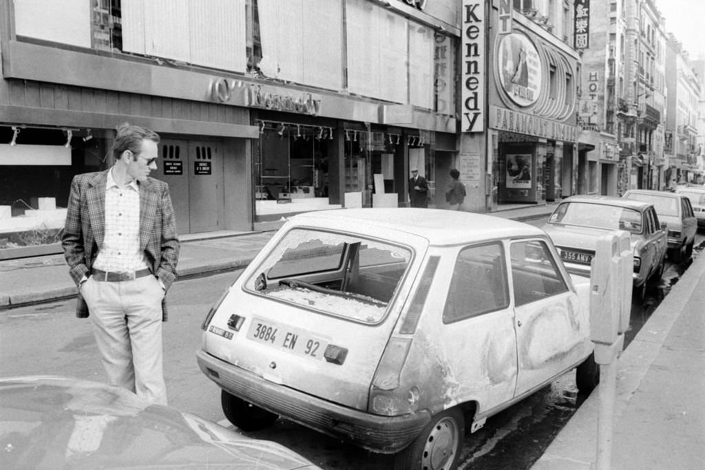 A passer-by looks at a burnt-out car following a violent demonstration during the trial of 16 Basque nationalists in Burgos, Spain, September 28, 1975.