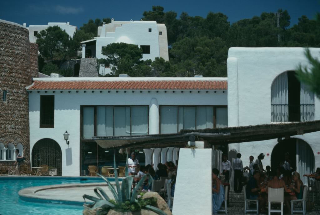 Dinera on a poolside terrace at the Hacienda Na Xamena hotel in Port de Sant Miguel, Ibiza, Spain, 1978.