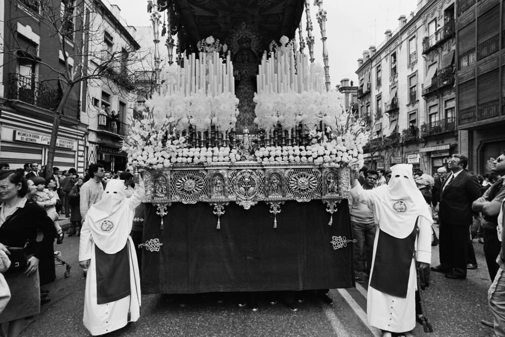 Celebrations for Holy Week (Semana Santa) underway in Seville with hooded penitents, known as 'Nazarenos' dressed in their traditional white robes as they prepare to take part in the religious processions through the city of Seville, Andalusia, 1985.