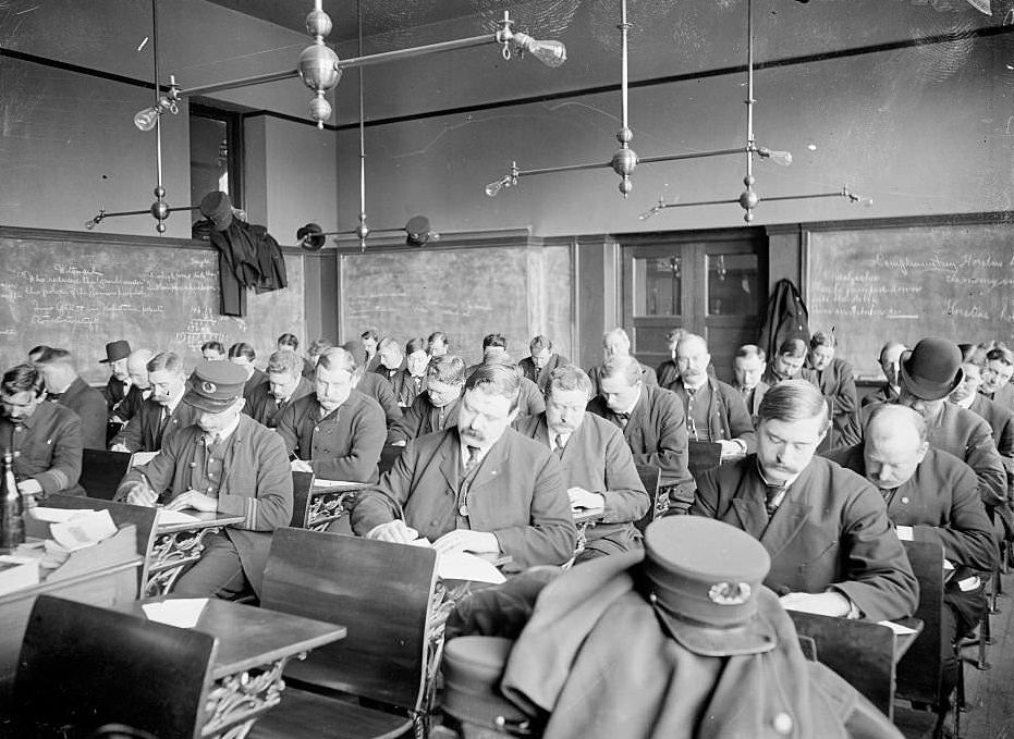 Policemen sitting in a classroom, taking the sergeants exam, Chicago, Illinois, 1904.