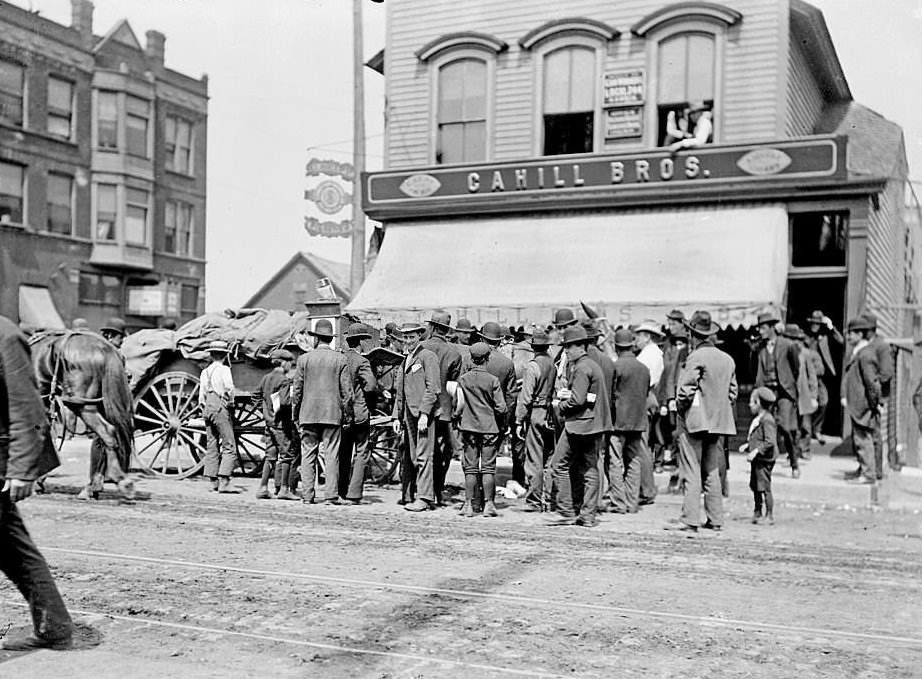 Men gathered outside the Cahill Brothers store, during a stock yard strike in the Halsted street area, Chicago, 1904.