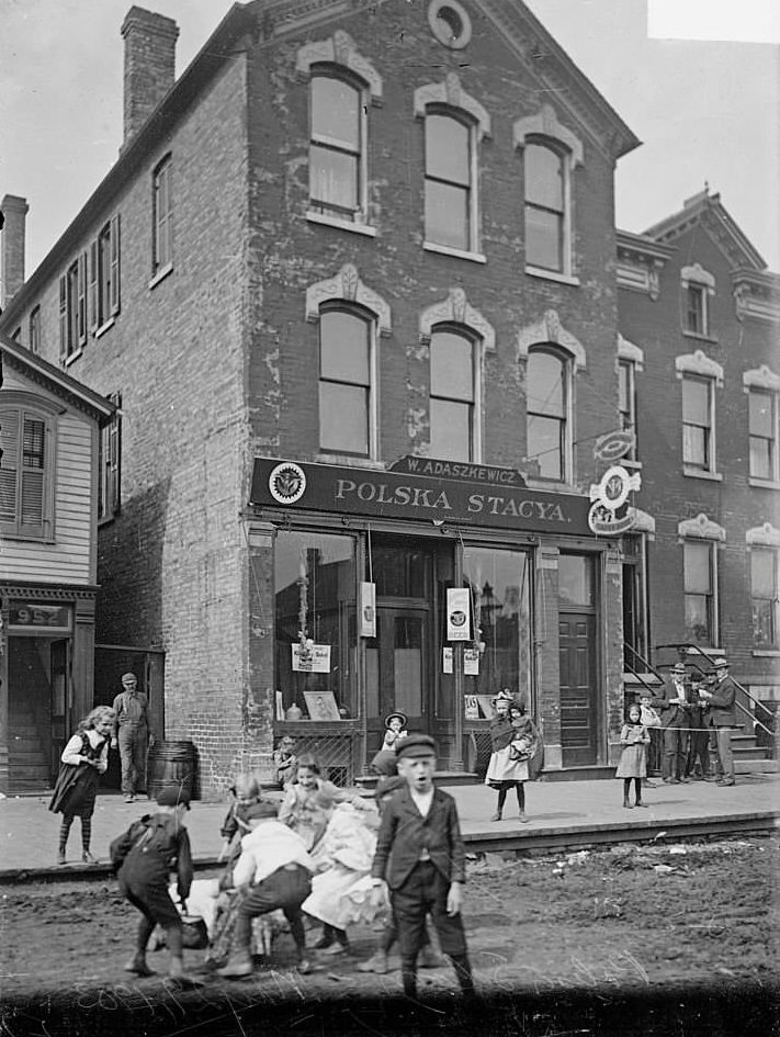 Polska Stacya, a Polish saloon, with children playing and men standing nearby, Chicago, Illinois, May 29, 1903.