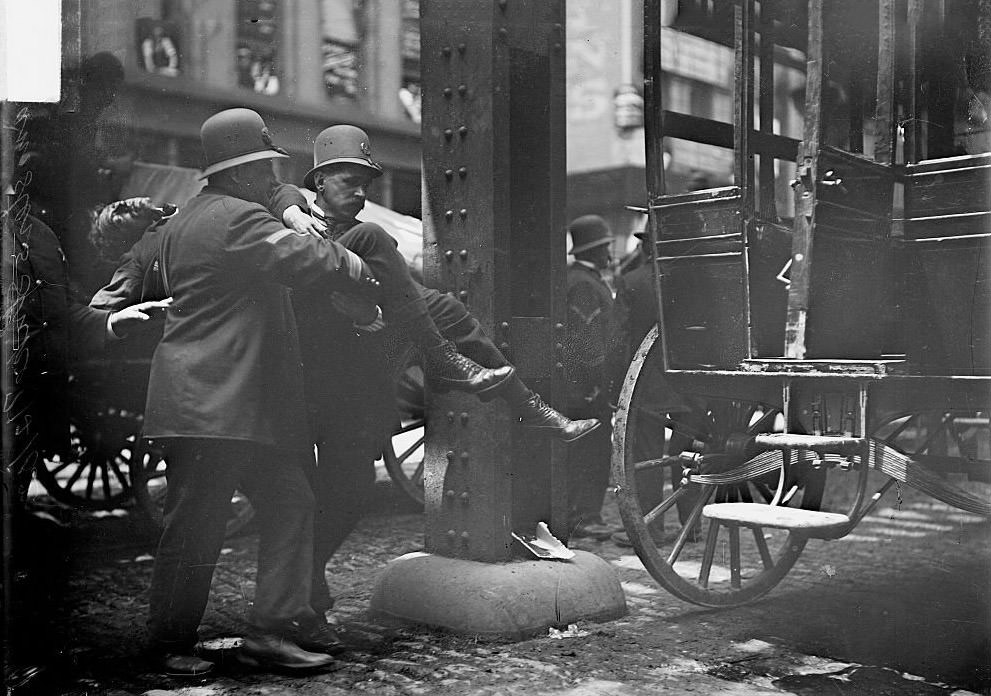 Wounded man being carried to an ambulance by two policemen during the Teamsters Strike, Chicago, Illinois, June 4, 1902.
