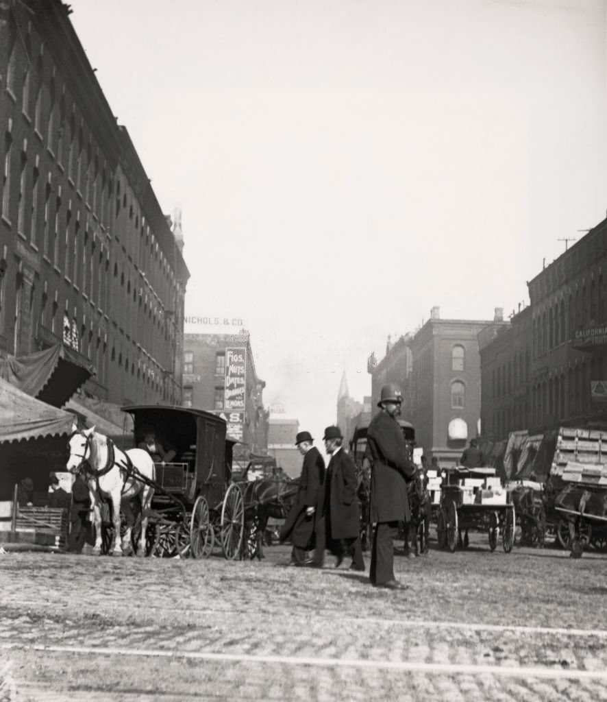 Low angle view of horse-drawn carts and carriages on South Water Street, as seen from Dearborn Street in Chicago, Illinois, 1905