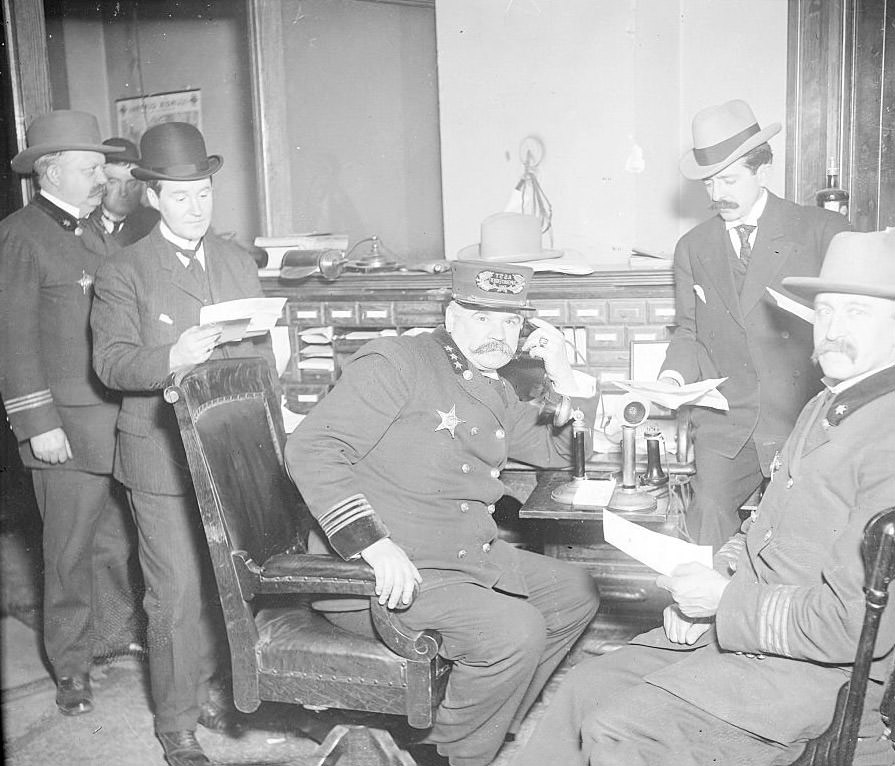 Assistant chief Herman Schuettler sitting at a desk in a room, Chicago, Illinois, 1900s.