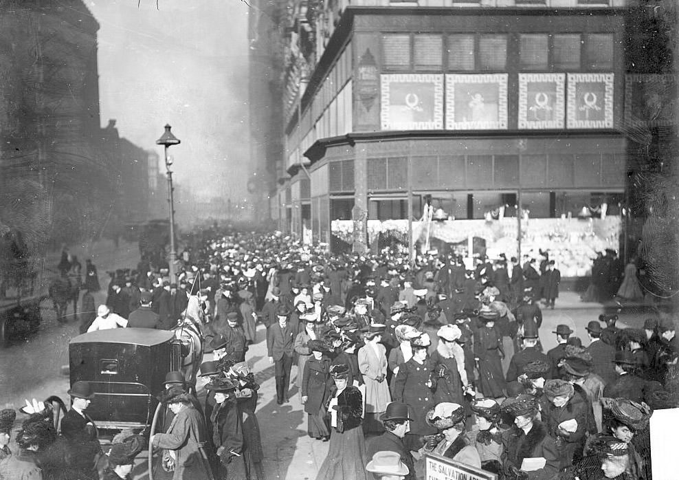Crowds of Christmas shoppers crossing the street and walking along the sidewalks in downtown, Chicago, Illinois, 1900s.