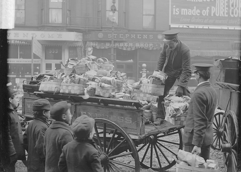 Salvation Army distributing turkeys, Salvation Army volunteers unloading Christmas food baskets from a wagon, 1900s.