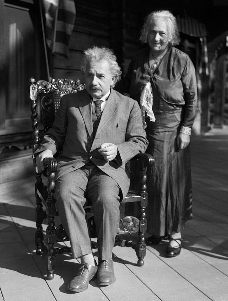 Albert and Elsa Einsteinn California. He is seated while she stands behind him.