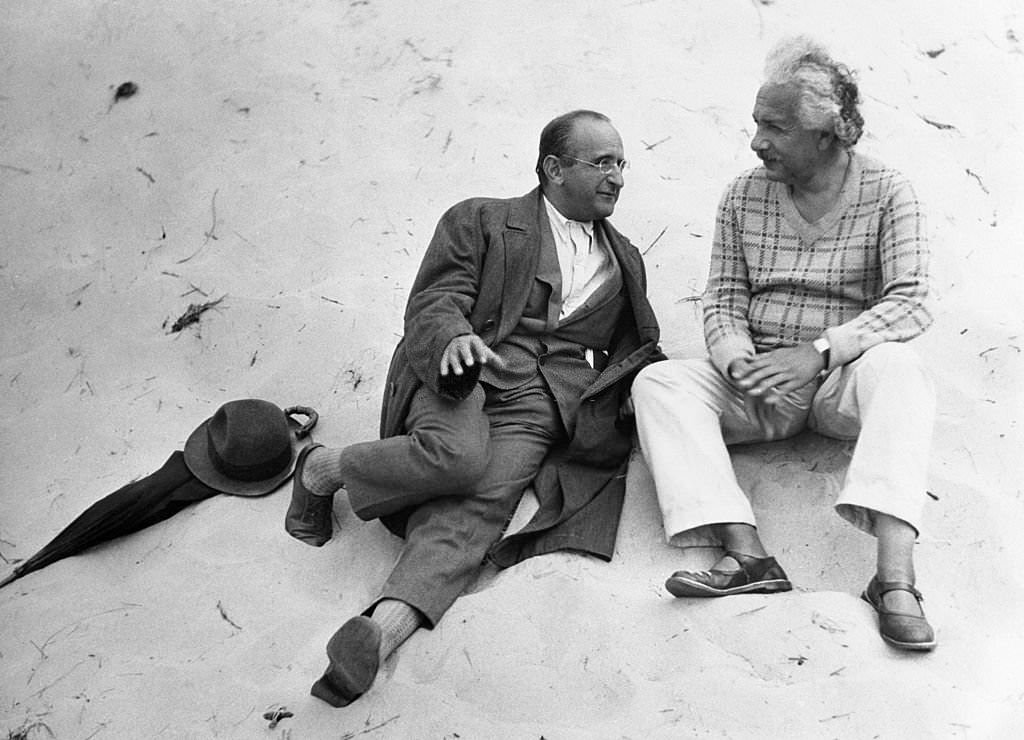 Albert Einstein and his colleague, Professor Walther Mayer of Vienna, go into a little relaxing dialogue on the beach at Coq-sur-Mer, Belgium,.