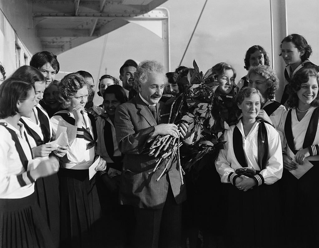 Albert Eisnstein with a group of women. He is holding a bouquet of flowers, 1932