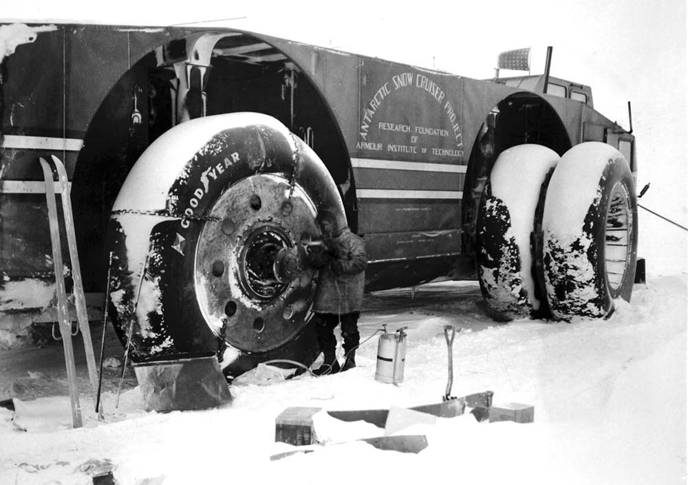 Sergeant Felix Ferranto, radio operator, works with a primus torch to thaw out the wheel motors of the Snow Cruiser on August 23, 1940.