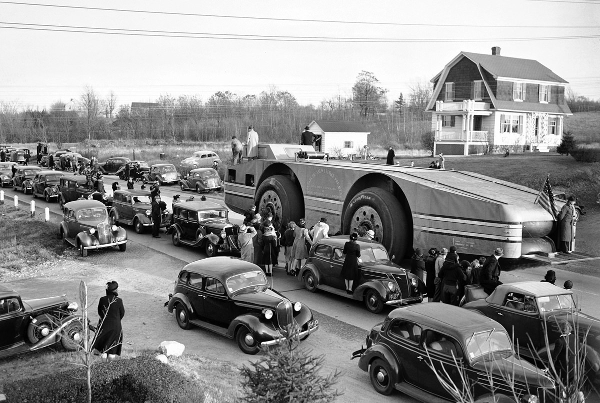 Admiral Byrd’s snow cruiser passes through traffic and onlookers before halting for the night in Framingham, Massachusetts, on November 12, 1939.