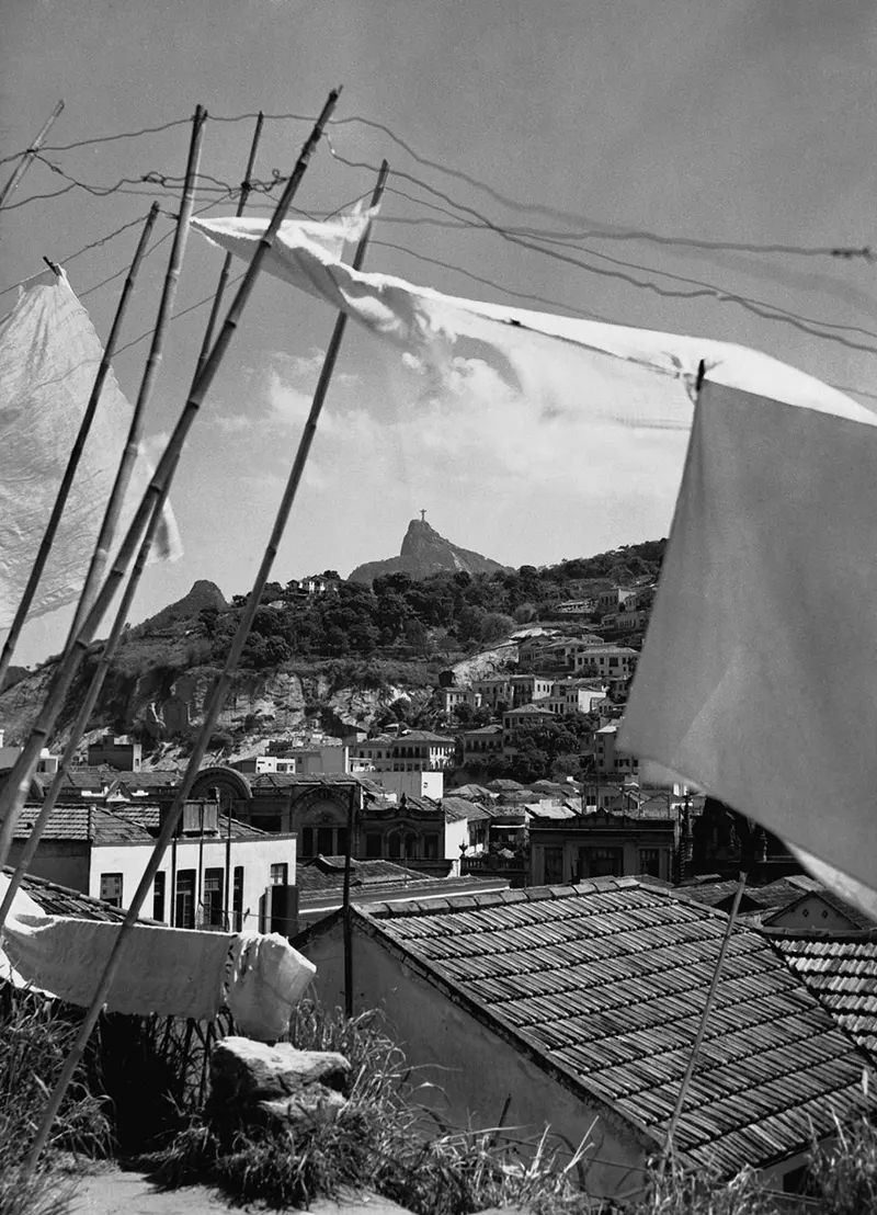Laundry dries in the wind, with the Christ the Redeemer statue visible in the distance.