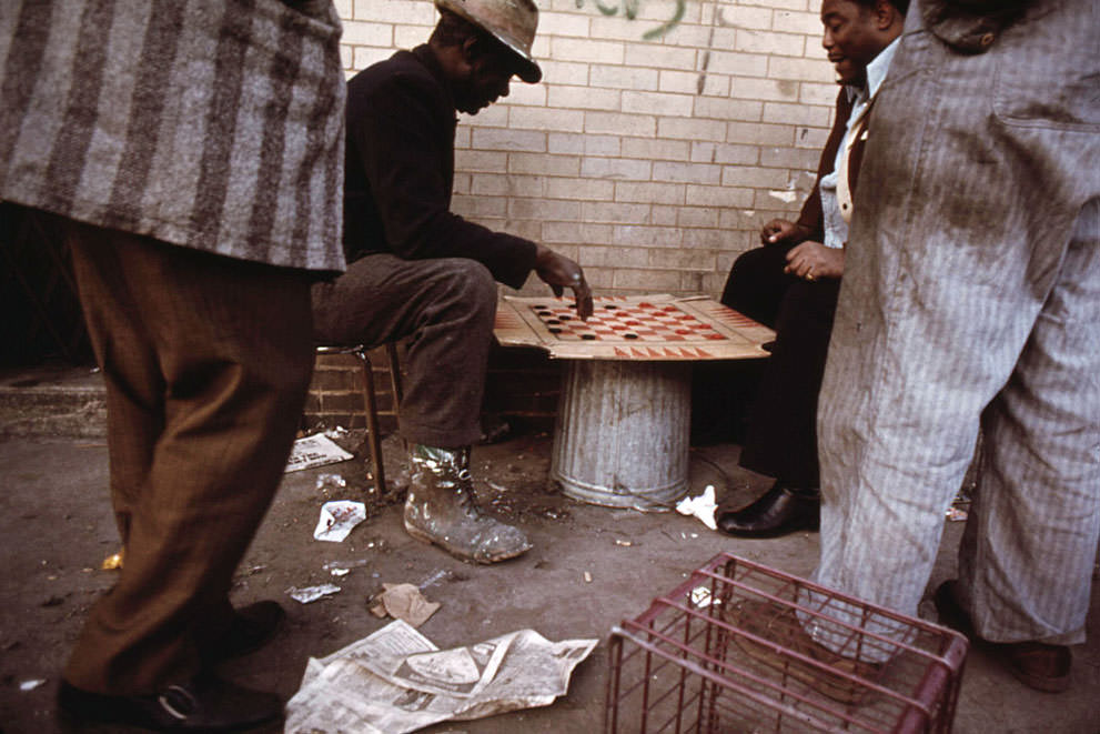 Workers pass the time playing checkers on East 35th Street before going to work in Chicago, in May 1973.