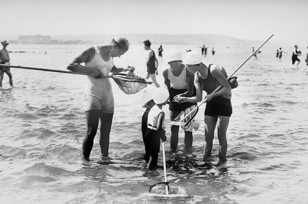 On the beach of Deauville in July 1929, children fished for shrimp with the help of a shrimping net.