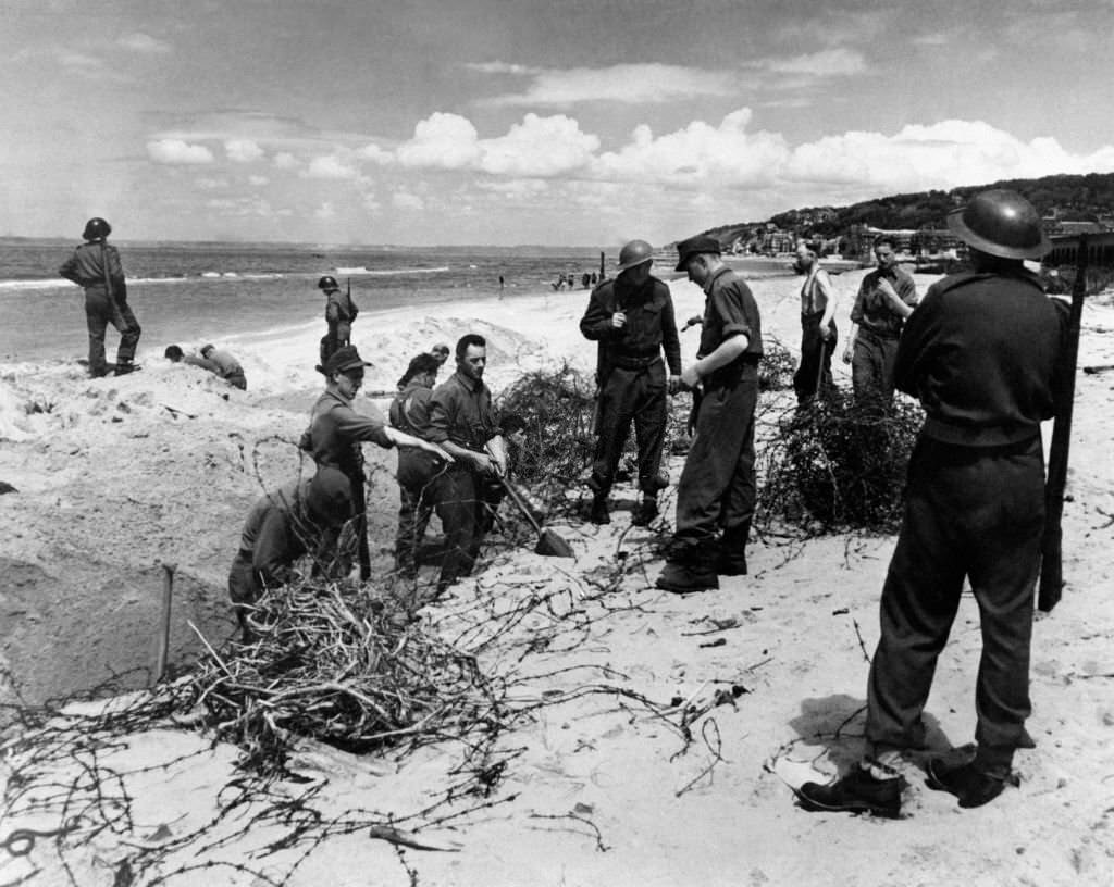 On Deauville beach, German prisoners of war line under the watch of English soldiers, 1946