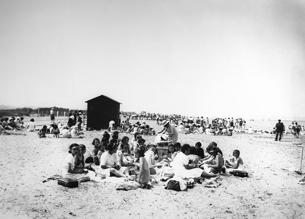 People enjoying the beach of Deauville during summer holiday on July 22, 1937 in Deauville, France.
