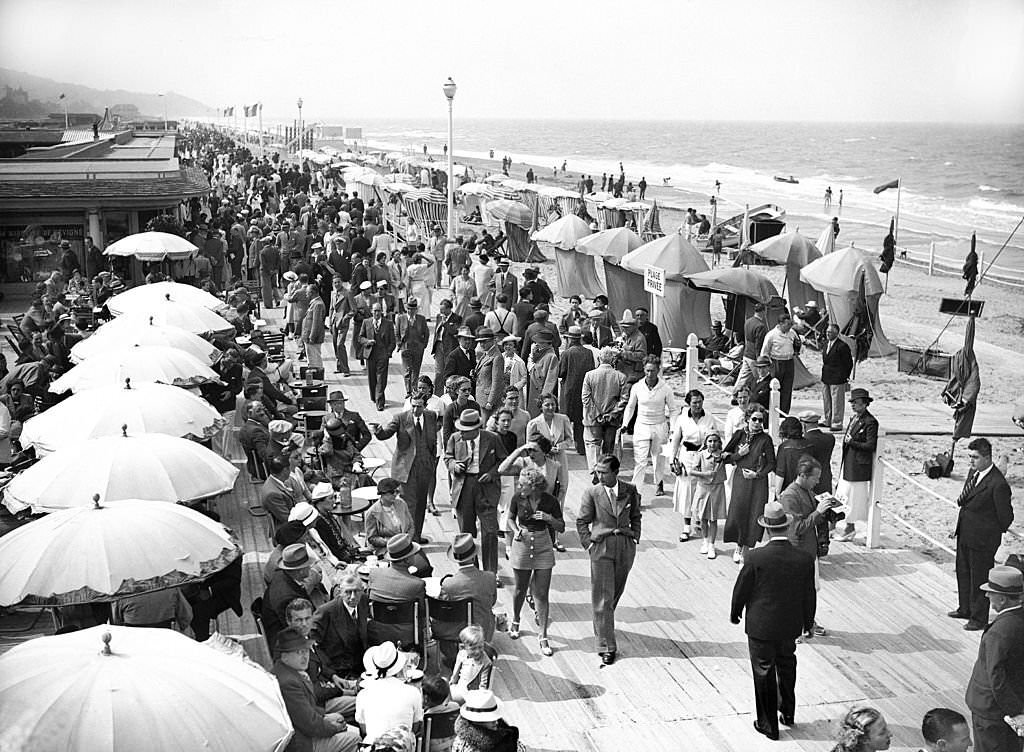 Vacationers on the beach and in front of the sea at Deauville, 1937