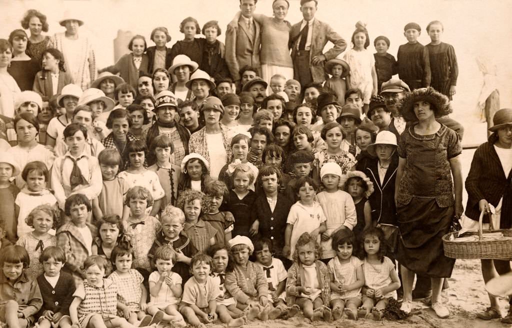 A large group of people including many small children on a holiday outing at a beach in France, 1920.