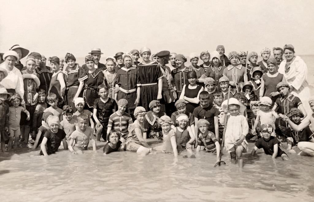 A large group of holidaymakers posing on the beach at Deauville, 1920