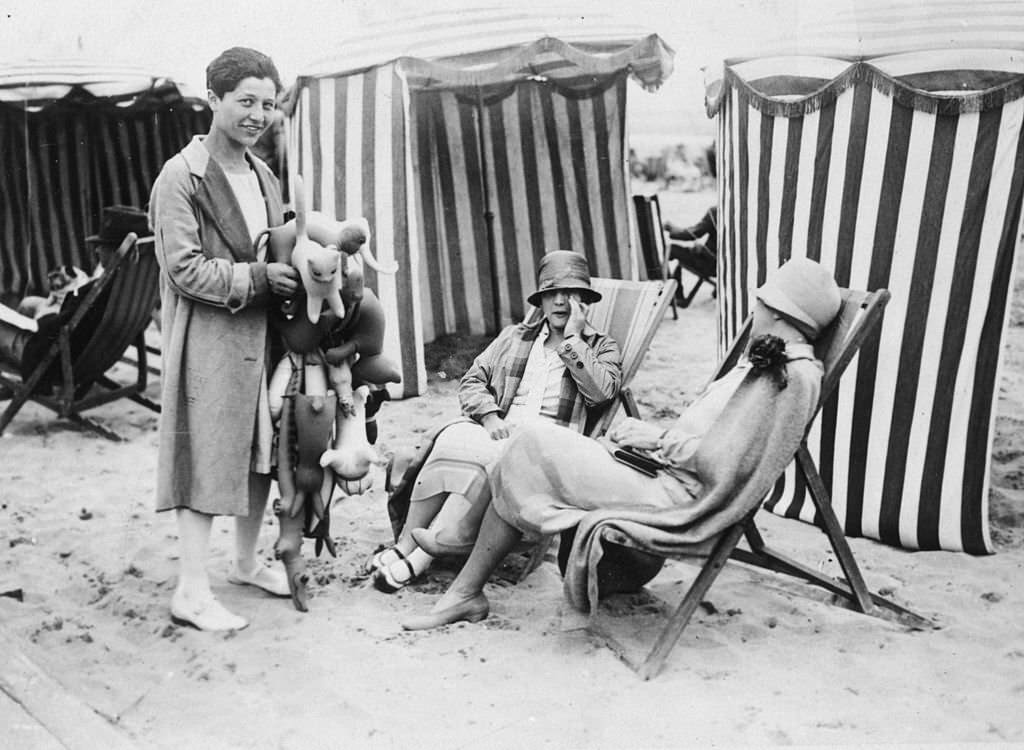 A girl selling rubber toys on the beach at Deauville, 1926