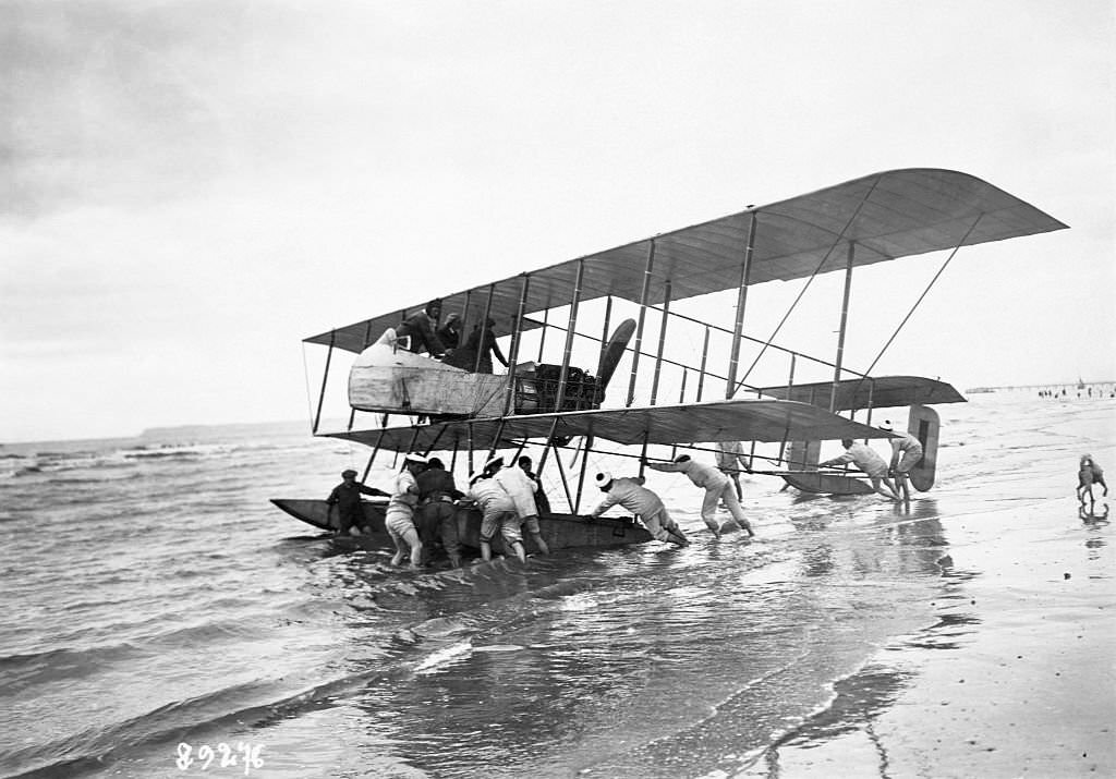 A ground crew pushed a floatplane into the water on the coast of Deauville, France. Eugene Renau will use the aircraft to compete in the 1913 Concours des Avions Marines.