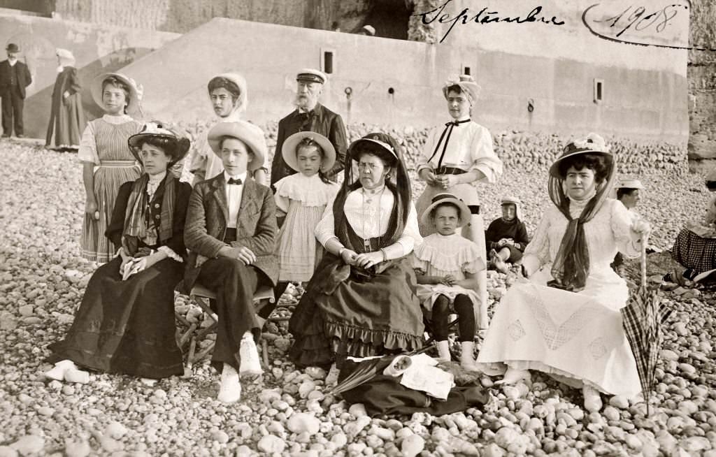 A family group in their Sunday best on a stony beach at Deauville, 1908
