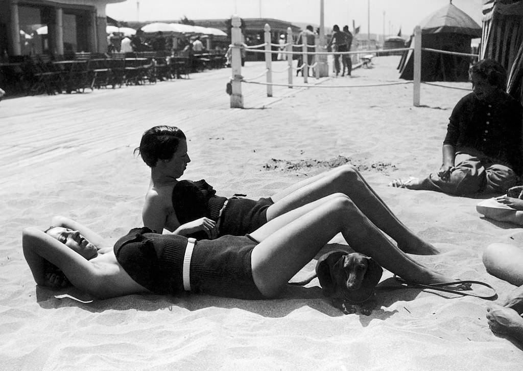 Deauville, women sunbathing on the beach accompanied by a Dachshund, 1935