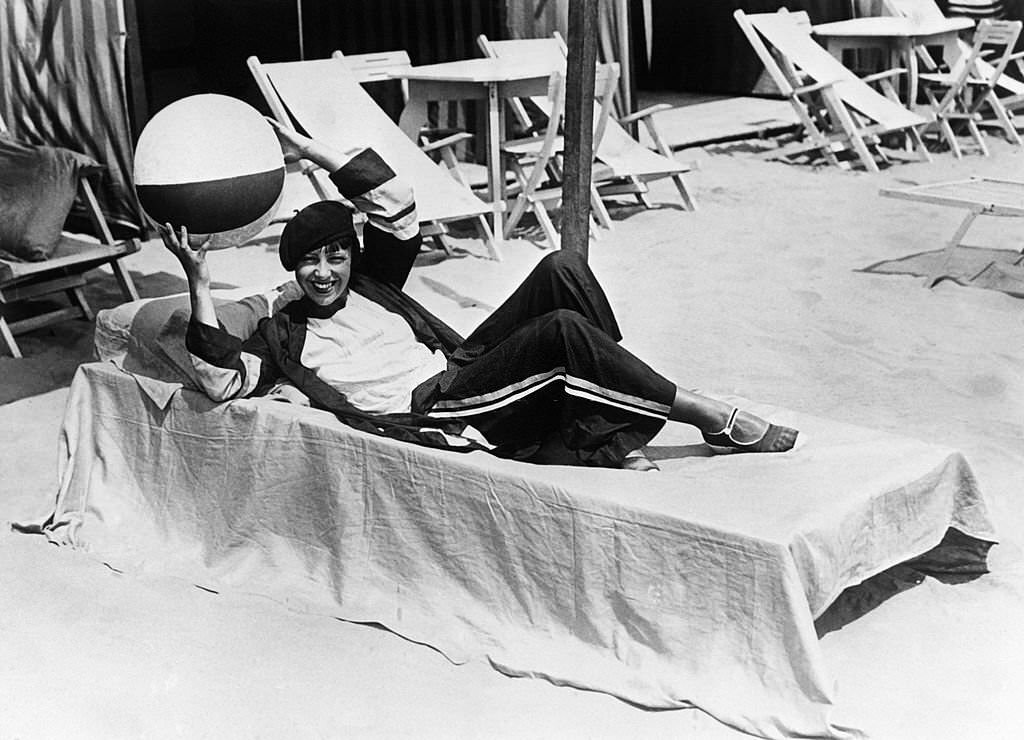 Woman on a deck chair on the beach in August 1929 in Deauville, France.