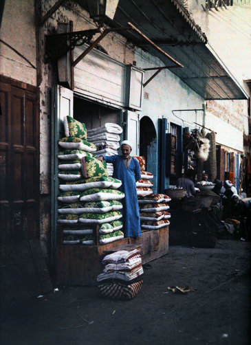 Man standing outside of his quilt and cushion shop in old Cairo.