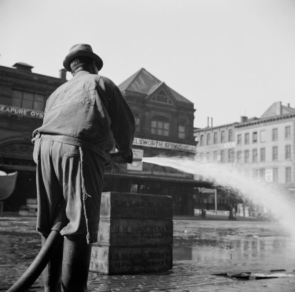 Workmen from the sanitary department flushing the street in front of the Fulton fish market late in the evening. Artist Gordon Parks, 1930s