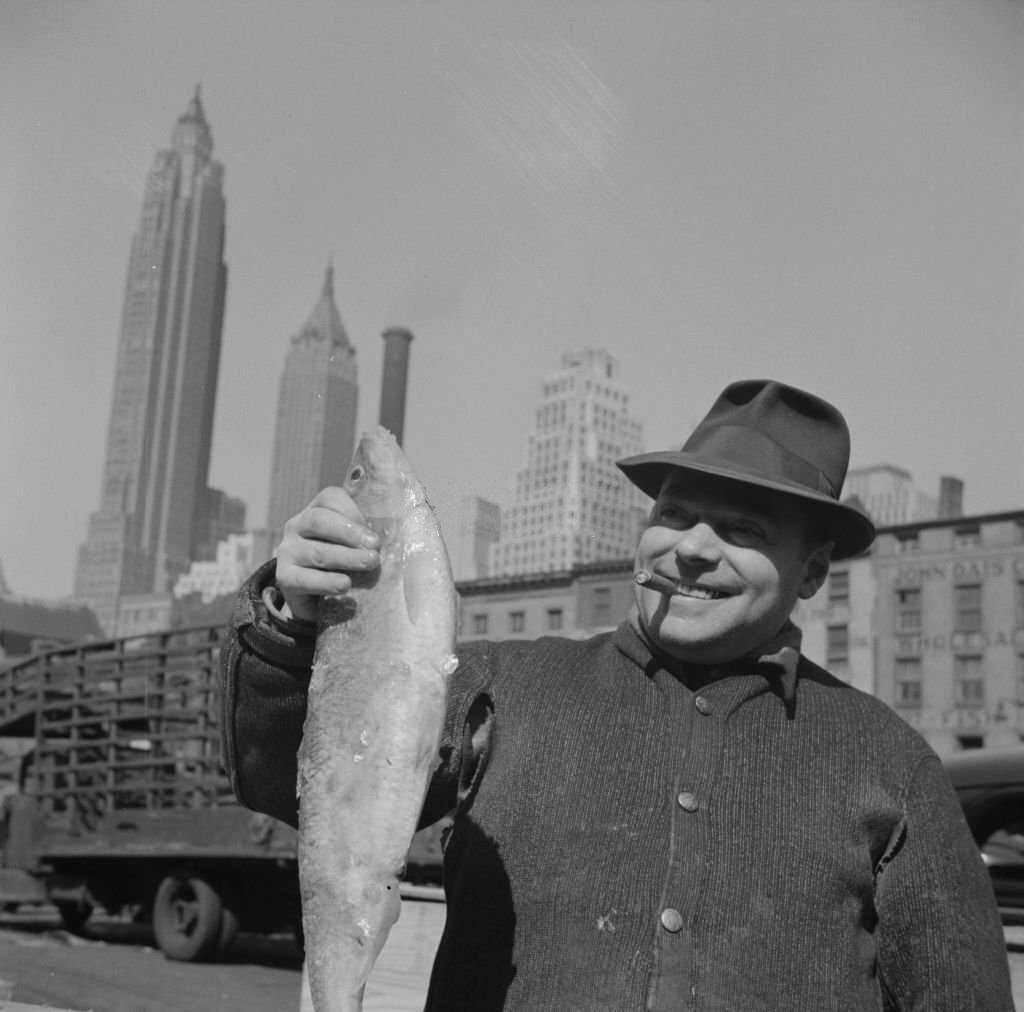 Fisherman holding a large catch at the Fulton fish market, 1934