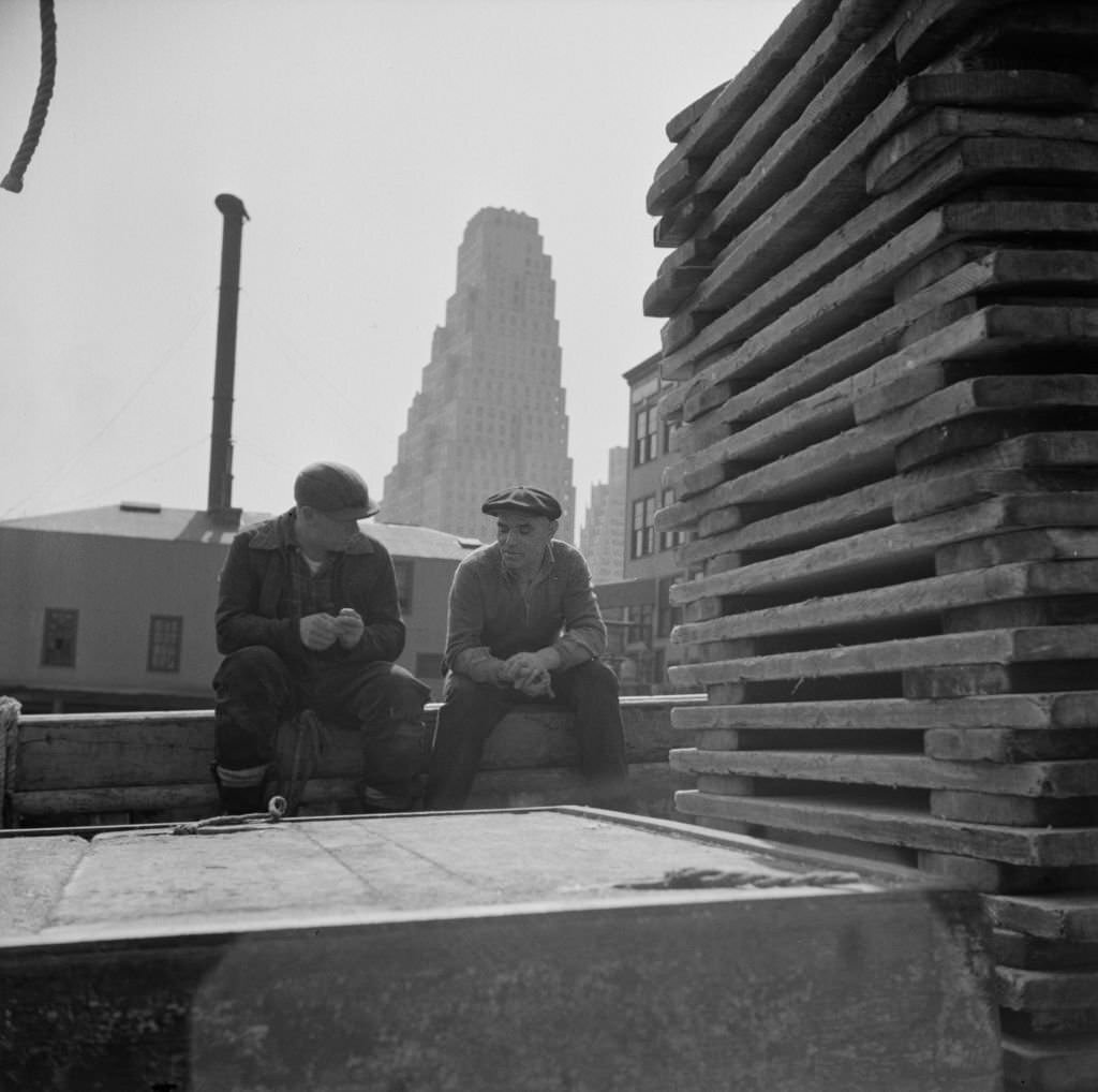 Gloucester fishermen resting on their boat at the Fulton fish market, 1930s