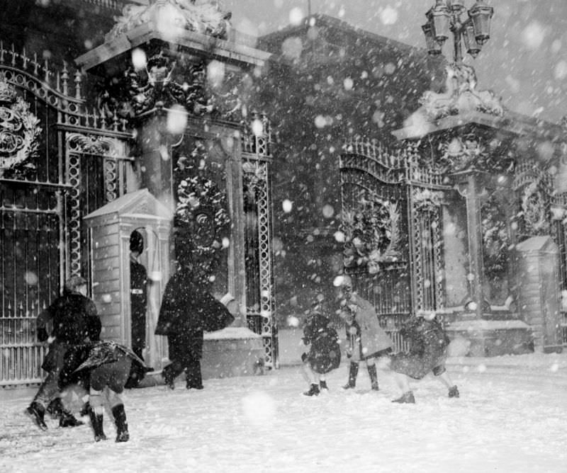 Children throw snowballs in front of Buckingham Palace, London, January 1955.