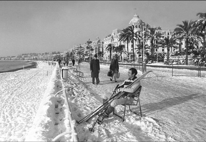 A man takes off his skis to rest at the Promenade des Anglais after rare heavy snowfall in Nice, France, January 1985.