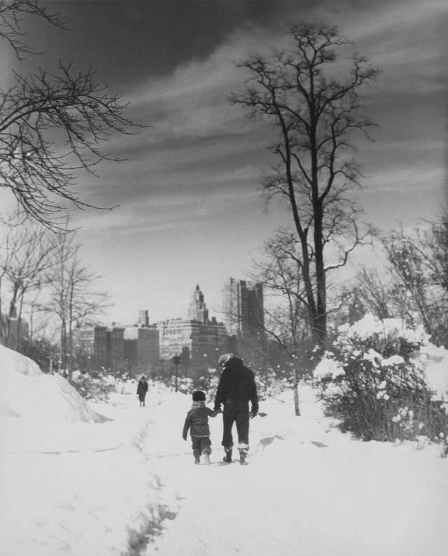 People walking on a snow-covered path, 1929.