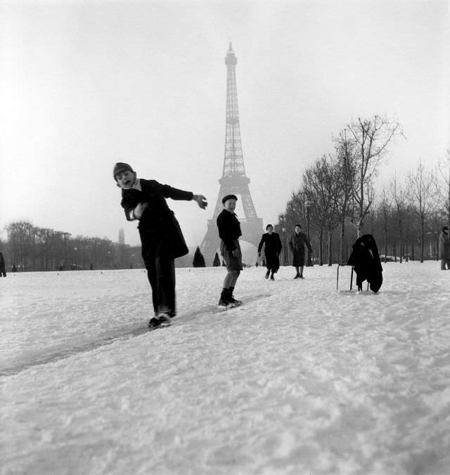 Children playing and sliding in the snow in front of the Eiffel Tower, 1945.