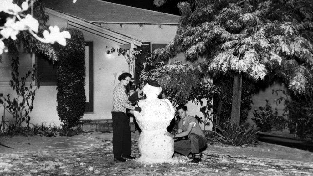 Mrs. and Mr. Harvey Tibbals put the finishing touches on a snowman outside their La Crescenta Avenue home in Montrose.